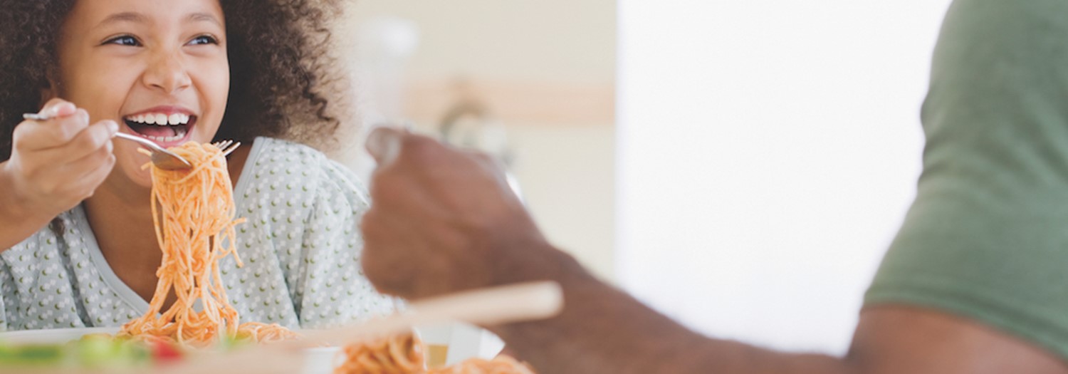 Girl Eating Pasta with Dad in the Kitchen